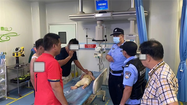 图为民警护送患病幼儿及其家属抵达医院进行救治