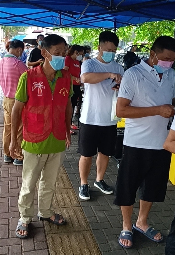 图为陈建新在核酸检测点位维持秩序