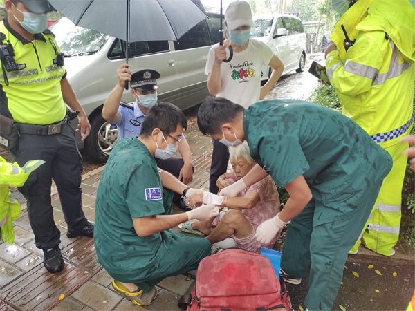 图为民警雨天为受伤被救助老人撑伞