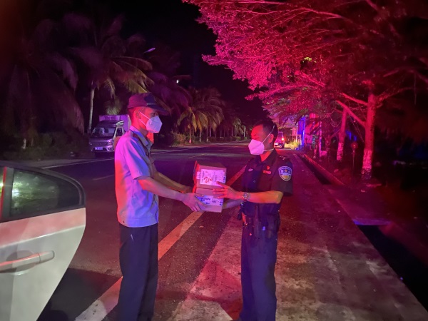 黄流海岸派出所民警唐明智将奶粉送到梅山交警队民警手中。许丁财摄