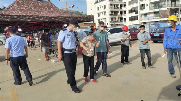 图为民警张佰仟在核酸采样现场帮扶行动不便的老人