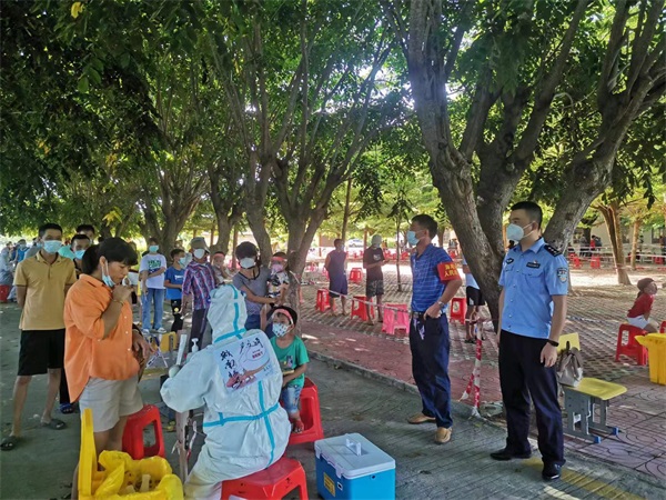 图为陈敏在核酸检测点执勤，维护现场秩序