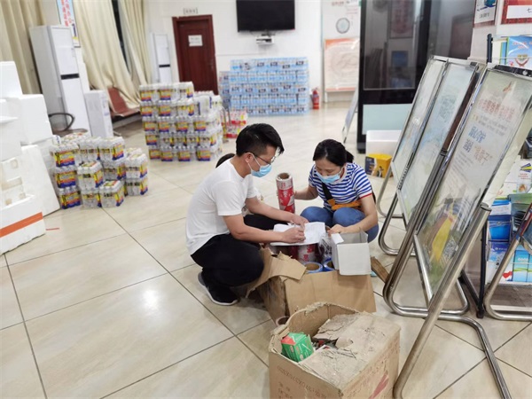 图为梁启秀在清点发放防疫物资