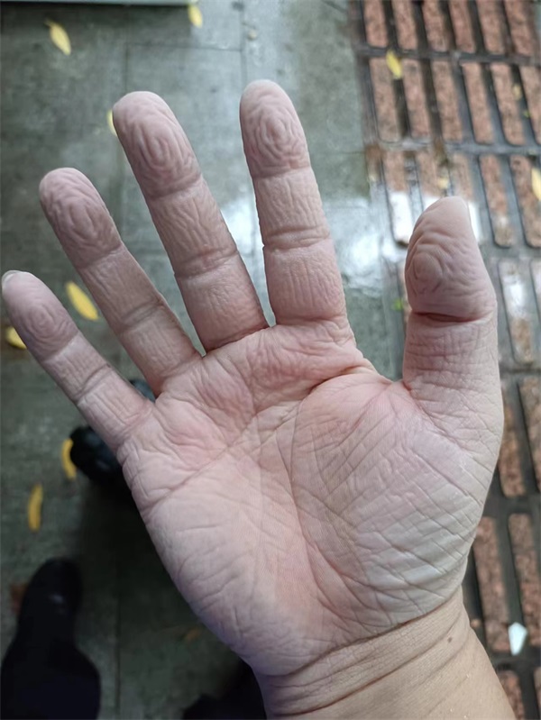 图为海岸民警在炎热天气双手在手套内被泡皱