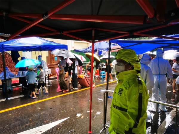 图为海岸民警在三亚疏导防护群众开展核酸检测工作