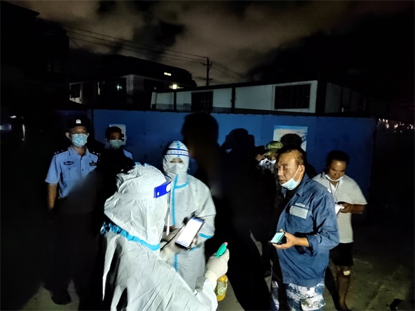图为新辅警配合医护人员引导渔船民做核酸
