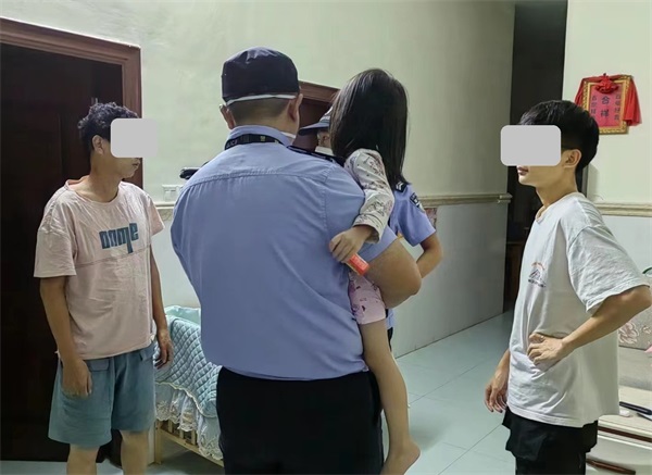 图为民警将小女孩平安送回家中