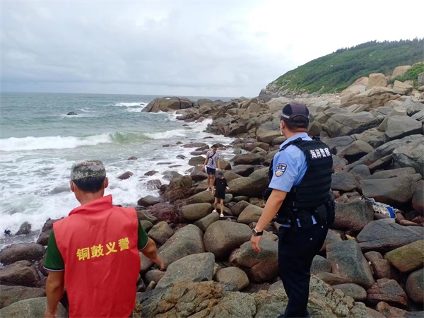 图5位龙楼海岸民警与铜鼓义警劝导群众离开非景区区域，返回景区