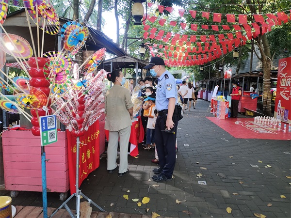 图为万绿园海岸派出所民警在万绿园景区与游客交流