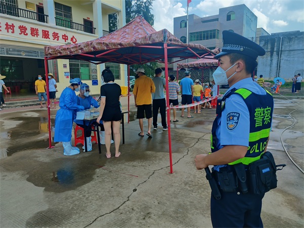 图为新海海岸派出所民警在荣山寮村核酸检测点执勤
