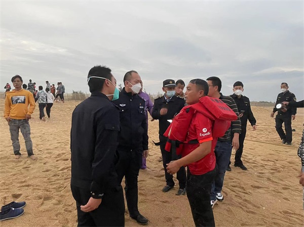 图为民警向被救助上岸的渔民了解相关情况 (2)