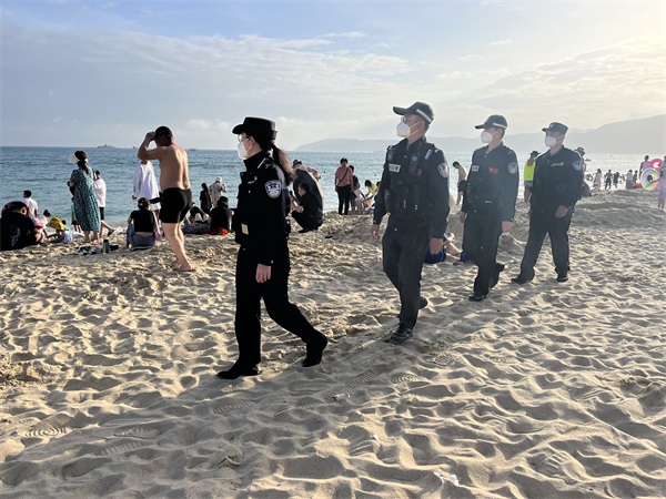 图为民警在景区沙滩进行徒步巡逻