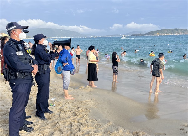 图为民警对下海的游客进行安全提醒