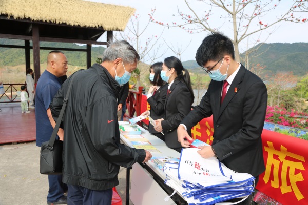 游客向昌江法院法官咨询法律问题，了解法治宣传手册内容（林小映 摄）