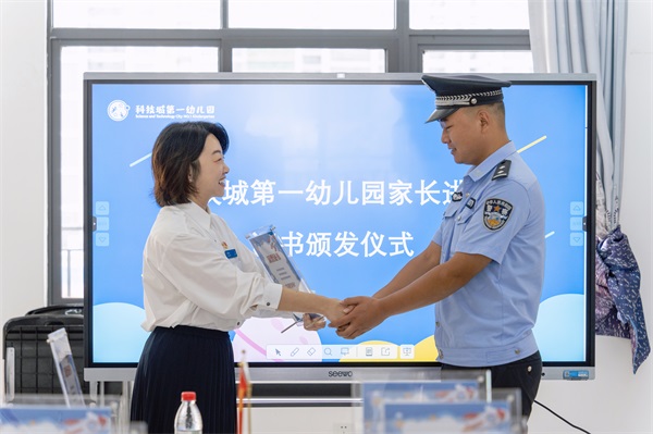 图为科技城第一幼儿园园长为民警李伟颁发特聘讲师证书