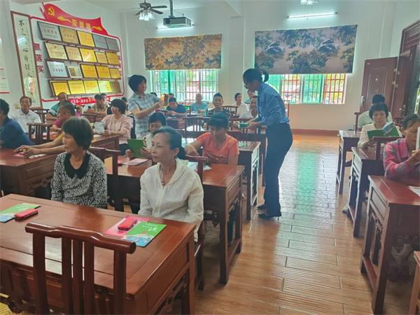 万宁市检察院联合妇联到乡镇开展家庭防护法治宣讲活动，图为检察干警向家长发放宣传手册