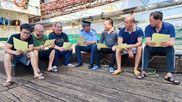 三亚港门海岸派出所党员民警向渔船民宣传休渔期法律法规。叶佳供图