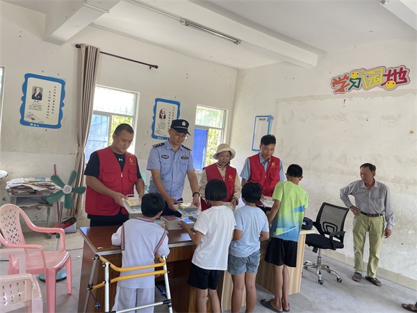 图为民警向孩子们赠送图书