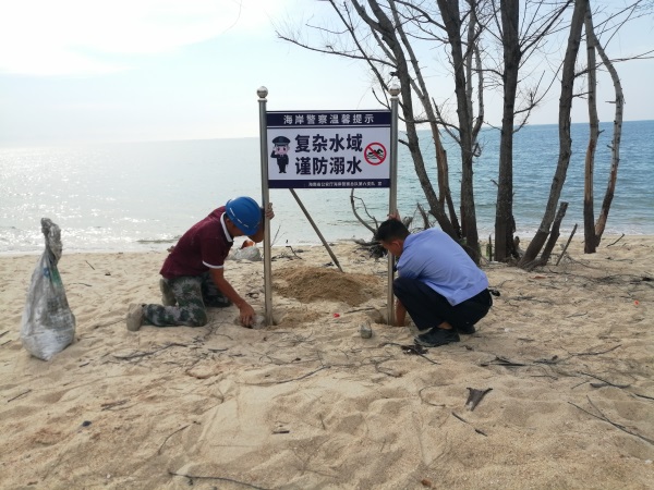 图为民警设置安装防溺水警示牌1