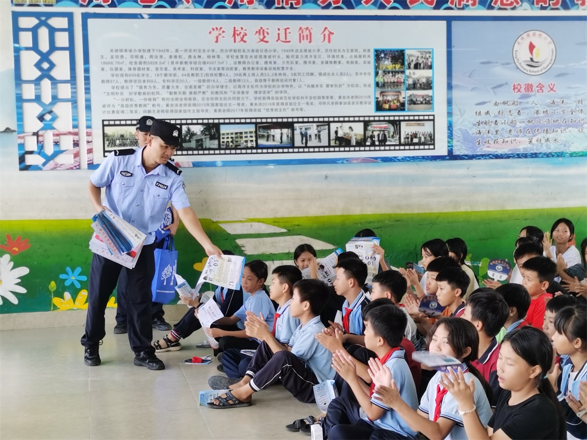 图为民警向学生发放宣传单