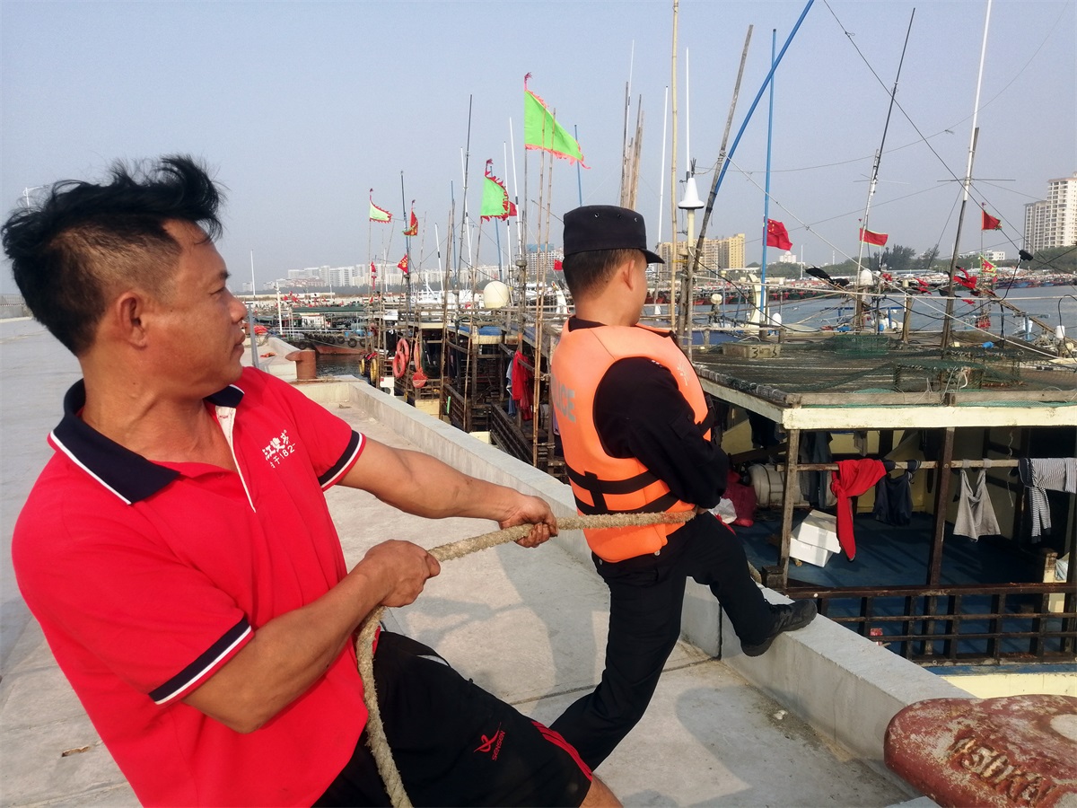 图为民辅警帮助渔船民加固船只，让渔民安心上岸过年