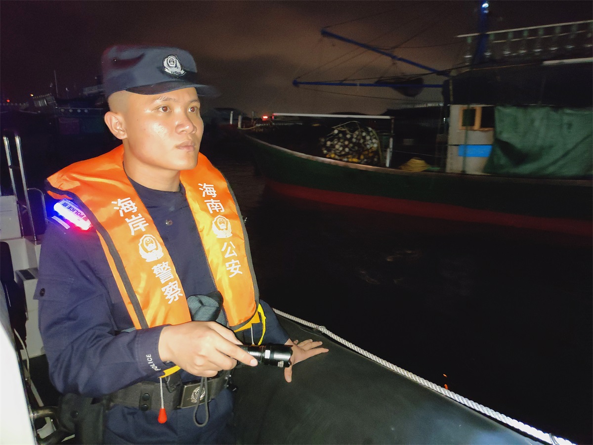 图为新村港海岸派出所海上警务室民警黄鹏夜间检查渔船。供图：黄恒