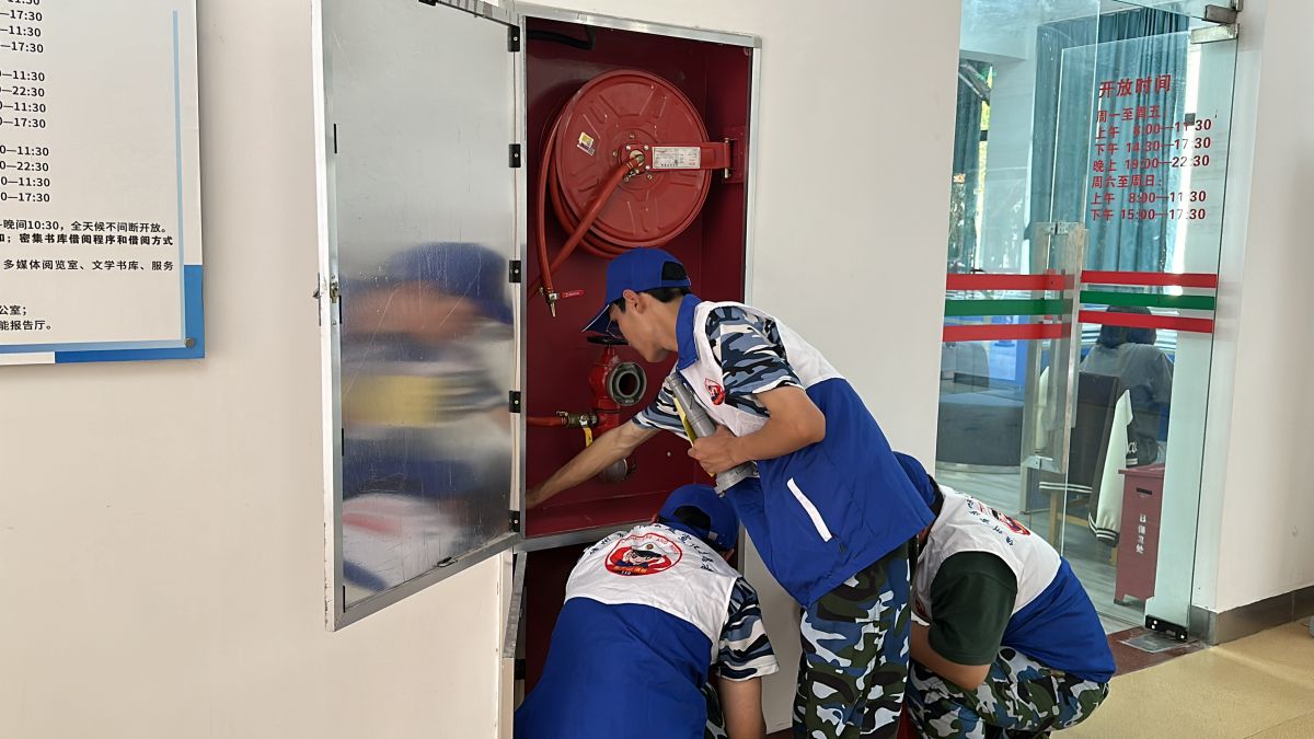 消防宣教员与大学生消防志愿者共同对校内消防设施进行清洁维护 (1)