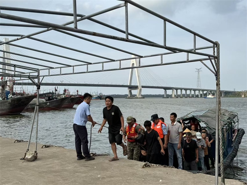 文昌市公安局木兰湾海岸派出所民警在铺前渔港码头帮助渔船民撤离上岸。吴平摄